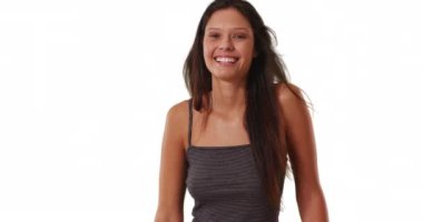 Güzel beyaz kız, çizgili kolsuz bluz giyiyor, saçları rüzgarda uçuşuyor. 20 'li yaşlarda esmer bir kadın stüdyoda gülüyor ve gülümsüyor. 4k