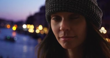 Venedik 'teki kadın turistin dramatik yakın plan portresi. 20 'li yaşlarda beyaz bir kızın İtalya' da tatilde kameraya bakarken çekilmiş fotoğrafı. 4k