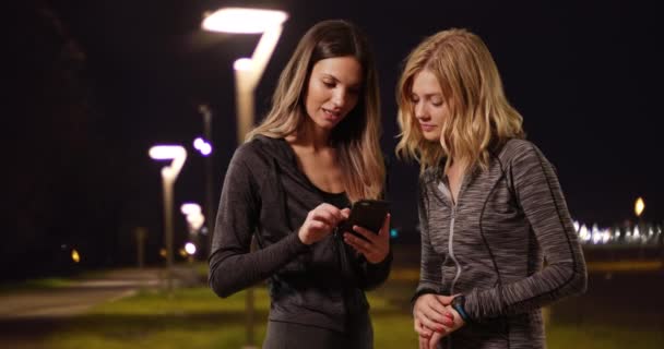 Sağlıklı Beyaz Kızlar Gece Koşusu Yaparken Kronometreye Akıllı Telefona Bakarlar — Stok video