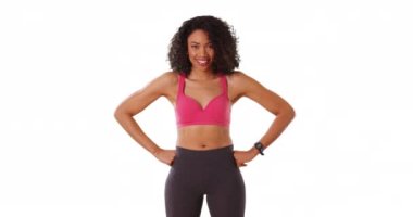 Güzel, güçlü siyah bir kadın beyaz arka planda kaslarını kopyalayarak kaslarını esnetiyor. Spor kıyafetleri içinde Afrikalı Amerikalı kadın portresi stüdyoda tonlu kollarını gösteriyor, gülüyor. 4k