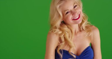 Sarı elbiseli, seksi mavi elbiseli, yeşil ekranda cilveli bir şekilde gülümseyen sarışın kadını çek. Anahtar ya da birleşik olmak üzere yeşil ekranda.
