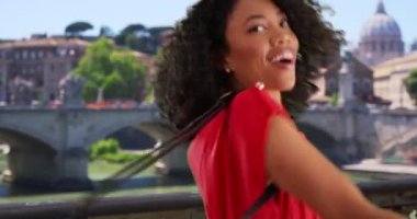 Roma 'da Vatikan' ın güldüğü ve daireler çizdiği mutlu siyah bir kadın. İtalya 'da tatilde olan mutlu Afrikalı Amerikalı turist dans ediyor ve gülümsüyor. 4k