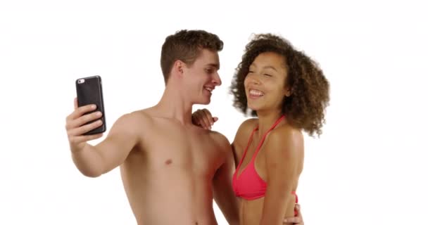 笑着的年轻夫妇在沙滩上自拍 背景为白色 拥有版权空间 夏天的一天 多种族的男性和女性一起在有复制空间的工作室拍照 — 图库视频影像
