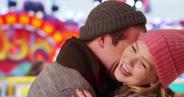 Kasaba panayırında eğlenceli bir randevuya çıkan beyaz bir çifti yakından çek. Karnavalda gülümseyen ve sevgi dolu genç bir erkek ve kadın. 4k