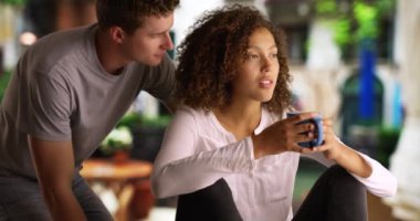 Güzel siyah kadın dışarıda erkek arkadaşıyla kahve içiyor. Çok ırklı bir çift Venedik 'te sakin bir sabahın tadını çıkarıyor. 4k