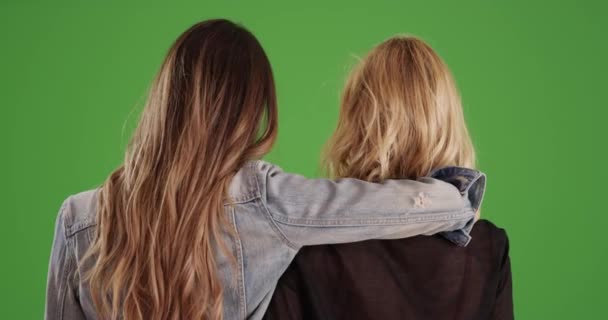 Yeşil Ekran Duvarında Birbirini Tutan Iki Arkadaş Canlısı Kızın Dikiz — Stok video