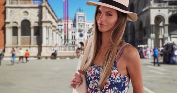 イタリアのヴェネツィアのサン マルコ広場で夏服の魅力的な女性の肖像画 セントマークス広場で帽子とルーマーを身に着けている彼女の20代のスタイリッシュな魅力的な女性 — ストック動画