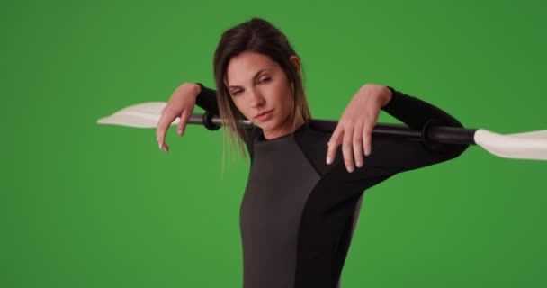 緑の画面上の肩の上にカヤックのパドルを保持ウェットスーツの女性を自信を持って ウェットスーツとオアを身につけた20代のスポーティな若い千年運動選手 — ストック動画