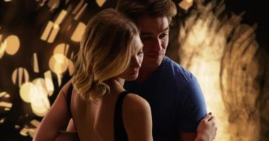 Sarışın ışık ve ağaçların arka planında birbirine yaslanmış yüzlerle kucaklaşan bir çift. Çekici erkek ve dişi akşamları şefkatle birbirlerine sarılıyorlar. 4k