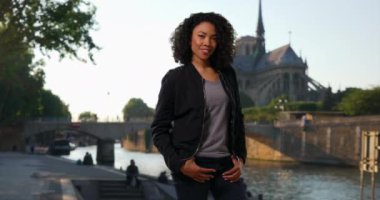 Sen nehrinin kıyısındaki sevimli Afro-Amerikan kadının gülümseyen portresi. Fransa, Paris 'te güzel, şık bir kadın portre için poz veriyor. 4k