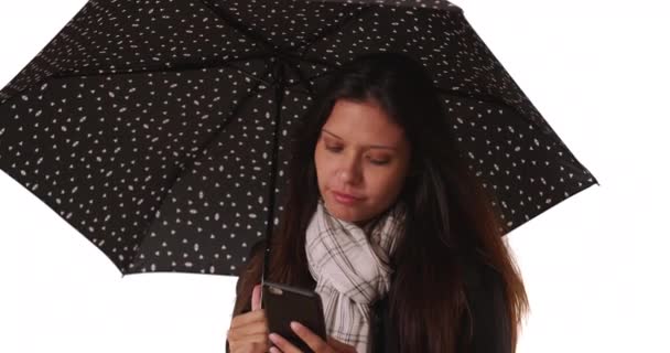Tisíciletá Žena Textové Zprávy Mobilem Zatímco Drží Deštník Bílém Pozadí — Stock video