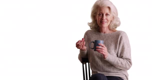 Vrolijke Oudere Vrouw Met Koffiemok Die Met Haar Vingers Knipt — Stockvideo