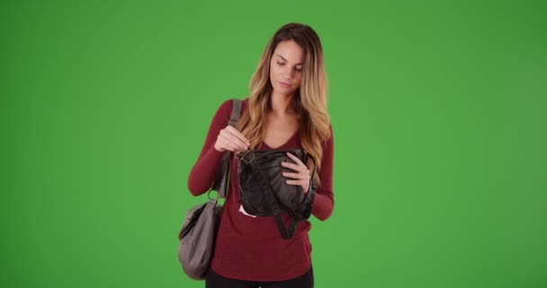 緑の画面で新しい財布やバッグを選ぶ若い白人女性 緑の画面でキーまたは構成されます — ストック動画