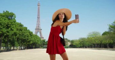 Güzel bir milenyum kızı Paris 'te selfie çekiyor. Mutlu ve çekici bir turist Eyfel Kulesi yakınlarında fotoğraf çeker. 4k