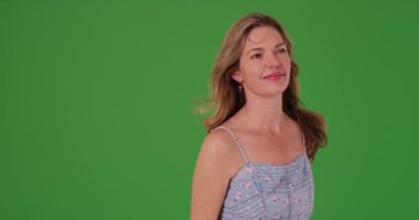 Yeşil ekranda gülümseyen orta yaşlı beyaz bir kadının portresi. Anahtar ya da birleşik olmak üzere yeşil ekranda.