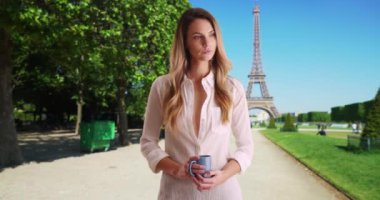 Paris 'te kahve içen dalgın bir kadın. Dışarıda kahve içen güzel beyaz kadın, arka planda Eyfel Kulesi. 4k