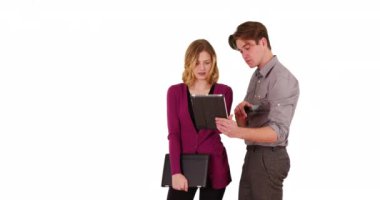 İş adamı, bayan iş arkadaşına stüdyoda fotokopi alanı olan bir şey gösteriyor. İki meslektaş dokunmatik dokunmatik cihaz kullanıyor. Telif uzayı ile beyaz arka planda işle ilgili konuları tartışıyorlar. 4k