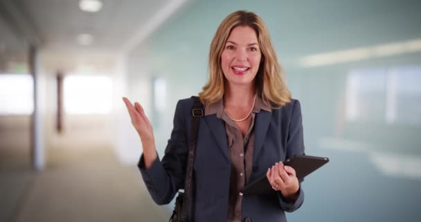 オフィスビルでタブレット端末を使用している中年の成人白人のビジネス女性 コピースペースとパッドを使用して笑顔のプロの労働者の肖像画 — ストック動画