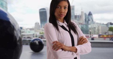 Londra 'da iş gezisinde başarılı bir zenci kadın şehir caddesinde duruyor. Londra Belediye Binası yakınlarındaki Afrikalı Amerikalı iş kadını kameraya özgüvenle bakıyor. 4k