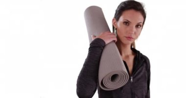 Beyaz fotokopi alanında yoga minderi tutan aktif kadın portresi. Saf beyaz arka planda paspası olan sağlıklı yoga kızına yakın çekim. 4k