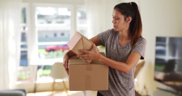美しい白人女性で自宅無料ボックスを運ぶ カジュアルなブルネットの女性が配達されるパッケージを保持する — ストック動画