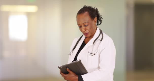 Μια Μεγαλύτερη Μαύρη Γιατρός Χρησιμοποιεί Σημειωματάριό Της Στο Γραφείο Της — Αρχείο Βίντεο
