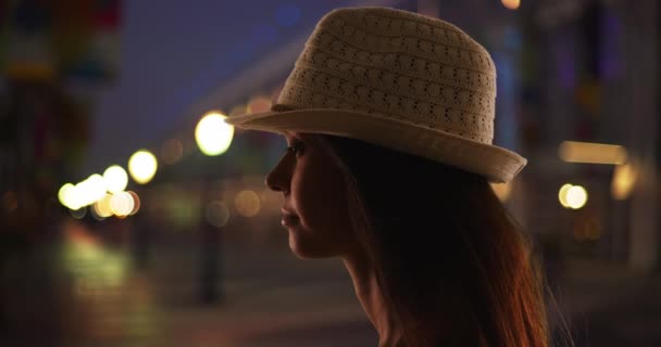深夜站在城市街道上的菲洛拉年轻女子的轮廓 一个漂亮的白人女人的侧视图 晚上在外面的表情更忧郁 — 图库视频影像