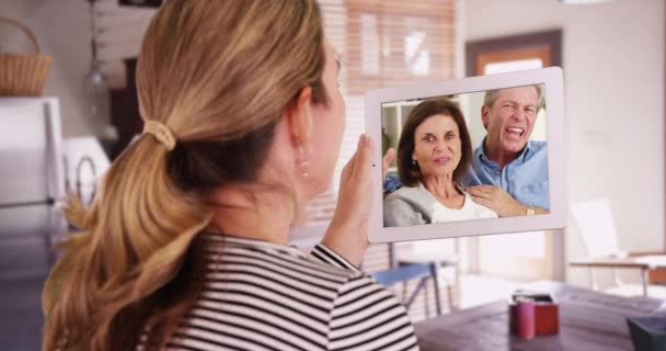 白人妇女视频用厨房里的平板电脑呼叫父母或家人 女性从背后通过家庭视频聊天与人交谈 — 图库视频影像
