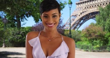 Paris 'te güzel siyah bir kadının güzel bir yaz elbisesi içindeki portresi. Paris, Fransa 'da Eyfel Kulesi manzaralı gülümseyen Afro-Amerikan kadın turist. 4k