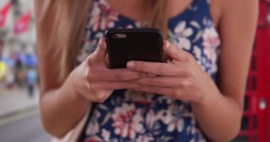 Londra, İngiltere 'de genç kadınların elleri telefonla mesajlaşırken çok yakından çekilmiş. Millennial in Romper, Londra 'da kapalı alanda akıllı telefon uygulaması kullanıyor. 4k