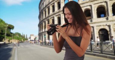 Roma Kolezyumu 'nun yanında duran güzel genç turist kadın DSR kamerasıyla fotoğraf çekiyor. Roma 'da seyahat fotoğrafçısı, İtalya' da sokak fotoğrafı çekiyor. 4k