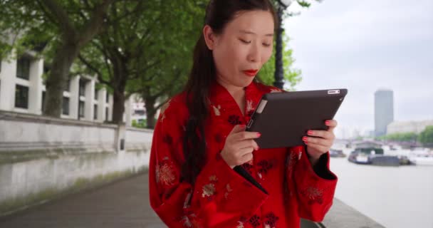 ロンドンのテムズ川のタブレットデバイスを使用して幸せな若い女性観光客 100万人の女性の笑顔を閉じ ヨーロッパでポータブルタブレットコンピュータを読んでください — ストック動画