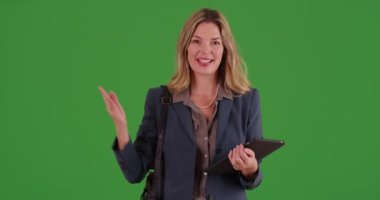 Orta yaşlı beyaz iş kadını yeşil ekranda tablet kullanıyor. Anahtar ya da birleşik olmak üzere yeşil ekranda.