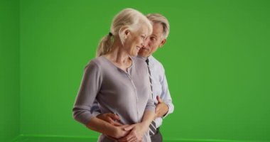 Yaşlı bir çift pencerenin önünde durmuş yeşil ekranda konuşuyor. Anahtar ya da birleşik olmak üzere yeşil ekranda.