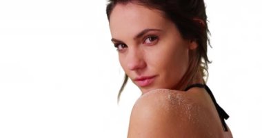 Beyaz arka planda telif uzayı olan beyaz arka plandaki kameraya bakan beyaz bin yıllık çekici bir beyaz kuşağa yakın çekim. Stüdyoda omzunda kum olan, iple bikinili güzel genç bir kadının yakın çekimi. 4k