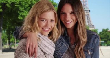 Eyfel Kulesi 'nin dışında sevinçle poz veren iki bayan arkadaş. Paris, Fransa 'da birbirine neşeyle sarılan birkaç beyaz kadın turist. 4k