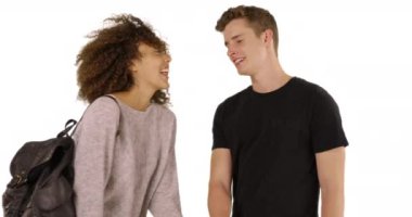 Mutlu ve çekici çift beyaz arka planda birbirlerinin gözlerinin içine bakar. Çoklu etnik erkek ve kadın ortak alan ile stüdyoda el ele tutuşuyorlar. 4k