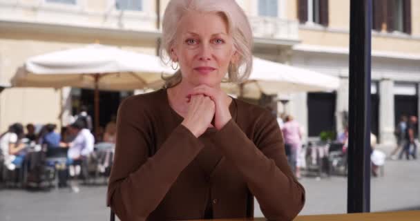 ローマのイタリアの休暇中にレストランに座っている古い白人女性観光客 カフェで食事を待っているシニア退職者はカメラを見ています — ストック動画