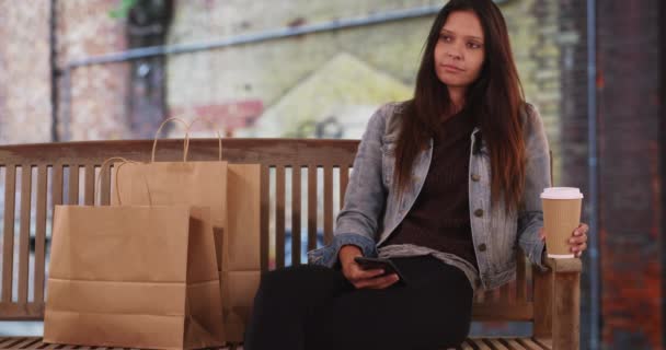 Hipster Lány Farmerdzsekiben Kávét Tart Nyilvános Padon Millenniumi Bevásárlószatyrokkal Emberek — Stock videók