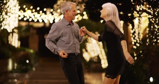 屋外で一緒に踊る甘いシニアカップル 幸せな高齢者が夜一緒に踊ります — ストック動画