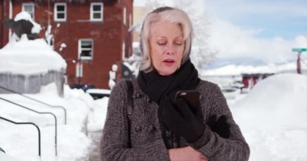 Elderly Woman Shivering Outdoors Snow Removing Glove Text Smart Phone — Stock Video
