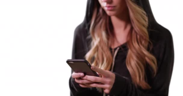 Blond Vrouwtje Een Hoodie Sms Met Mobiele Telefoon Witte Achtergrond — Stockvideo