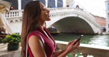 Venedik 'te mesajlaşan neşeli, gülümseyen genç Latin kadın. Büyük Kanal 'da 4G cihazı kullanan mutlu ve çekici bir Latin kadın. 4k