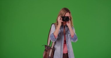 Dost canlısı bayan turist ya da fotoğrafçı yeşil ekranda kişinin fotoğrafını çekiyor. Anahtar ya da birleşik olmak üzere yeşil ekranda.