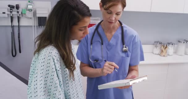 Retrato Cerca Enfermera Médica Revisando Historia Clínica Con Una Joven — Vídeos de Stock