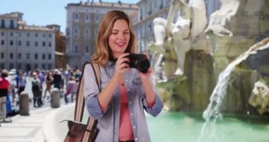 Gezgin fotoğrafçı, Piazza Navona 'da kamerayla fotoğraf çekiyor. Avrupa tatilinde fotoğraf çeken mutlu kadın turist. 4k