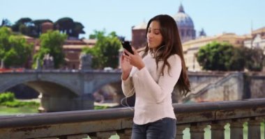 Şirin İspanyol kadın Roma 'da akıllı telefonundan çalma listesine girmeye çalışıyor. Kulaklık takmış, müzik dinleyen kaygısız bir kadının portresi. 4k