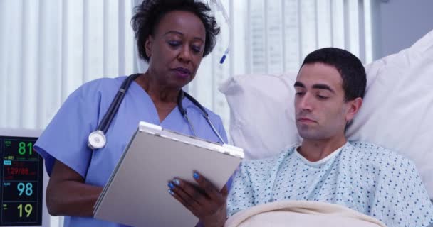 Чоловік Який Лежить Лікарняному Ліжку Одужує Старша Чорна Медсестра Ставить — стокове відео