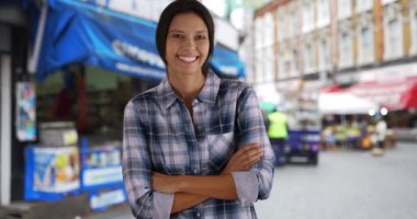 Brixton Caddesi pazarında mutlu ve çekici bir kadının sıradan portresi. Güzel beyaz kadın Londra 'nın dışında kameraya gülümsüyor. 4k