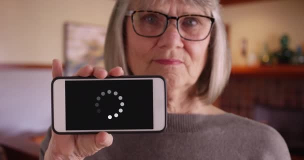 Ώριμη Λευκή Κυρία Που Κρατάει Τηλέφωνο Στην Κάμερα Για Δείξει — Αρχείο Βίντεο